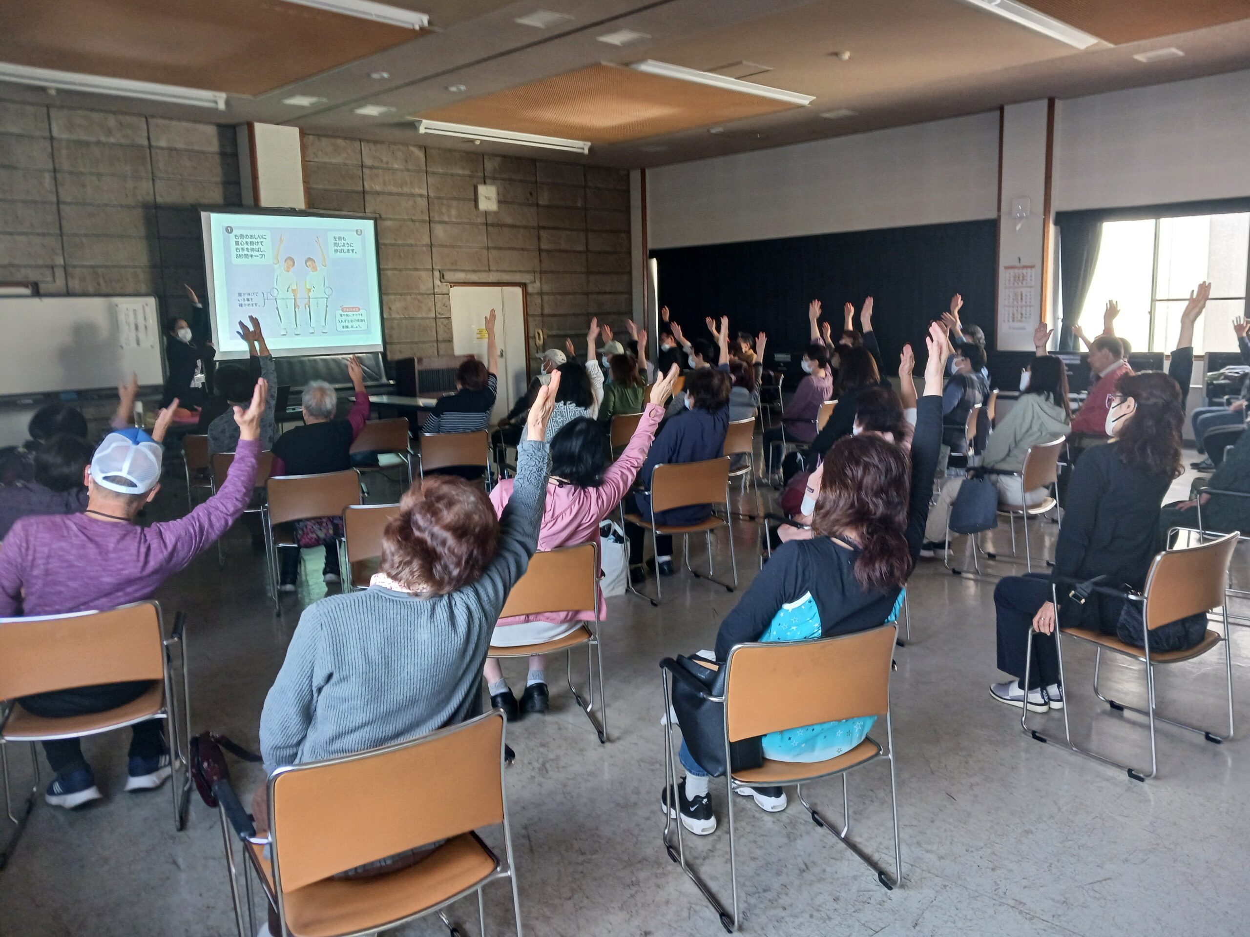 座ったままできる腸トレ体操に取り組む様子